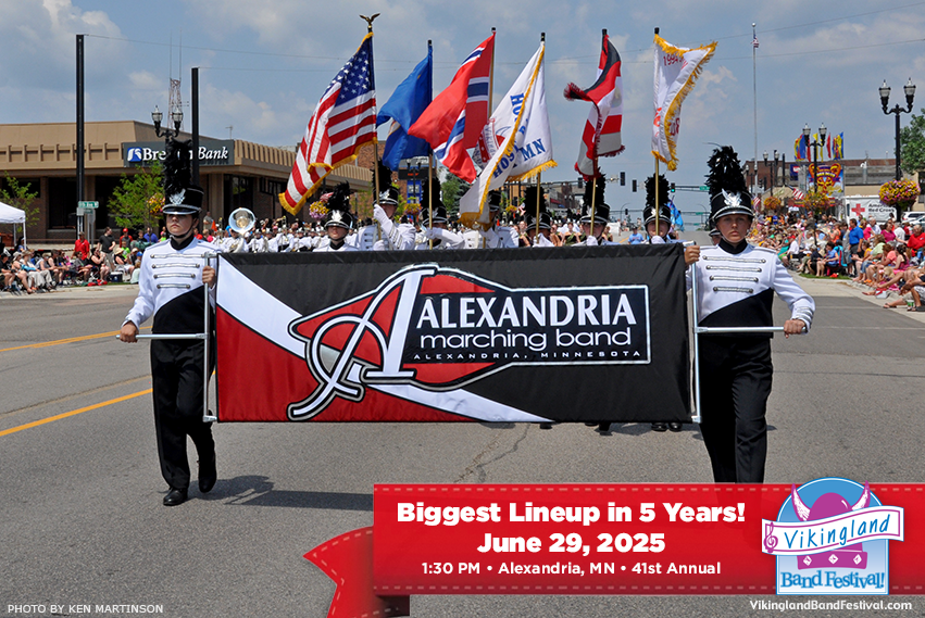 Members of the Alexandria Marching Band parade down a street, holding a large banner. American and state flags wave behind them as a crowd watches. Celebrate at the Vikingland Band Festival on June 29, 2025!.