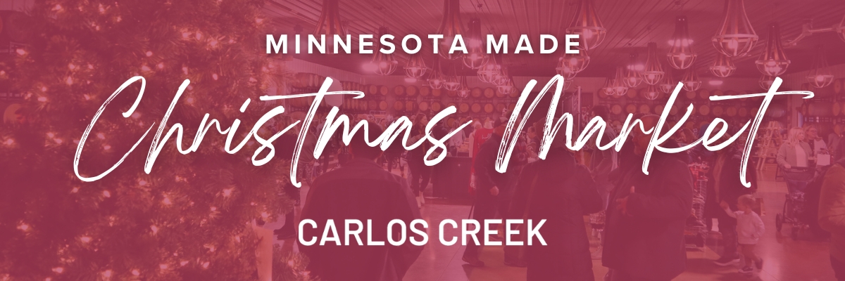 A festive indoor Christmas Market with a decorated tree, people shopping, and the text “MN Made Christmas Market, Carlos Creek” overlaid in large, stylish lettering.