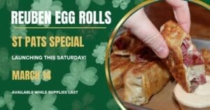 A hand dips a Reuben egg roll into sauce, with text advertising Copper Trail Brewing’s St. Pats Weekend special launching March 14, available while supplies last, on a green shamrock background.